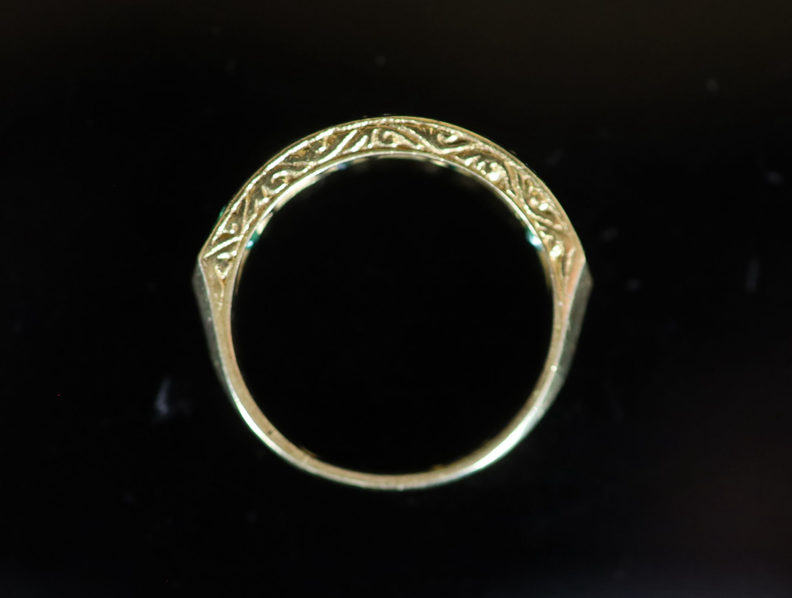 A modern 18ct gold, four stone emerald and three stone diamond set half hoop ring